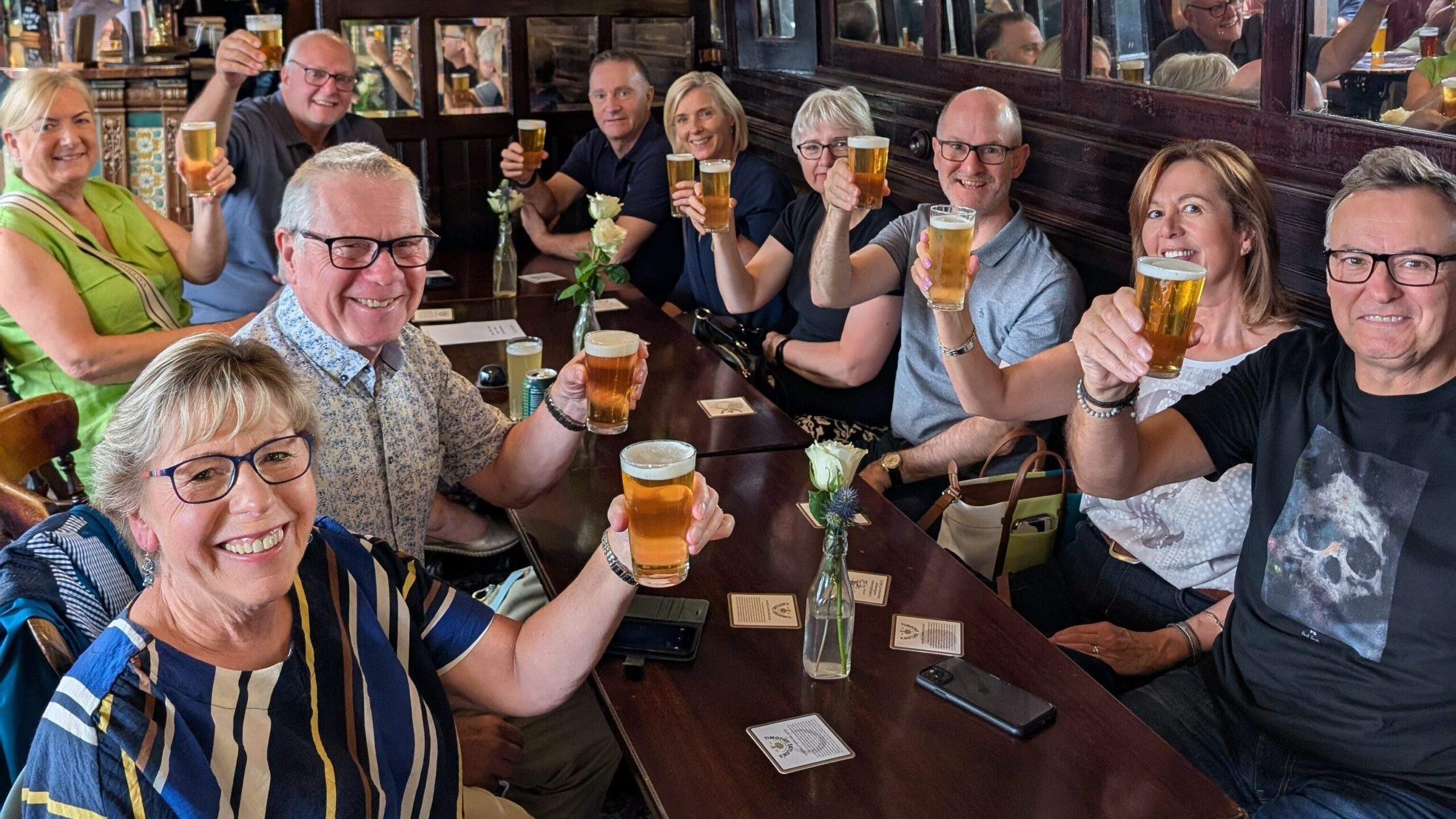 Tour guests toasting drinks towards the camera in Whitelock's Ale House